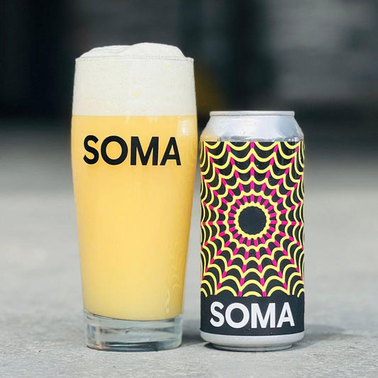 SOMA beer in a glass and can, showcasing vibrant design and refreshing golden color.